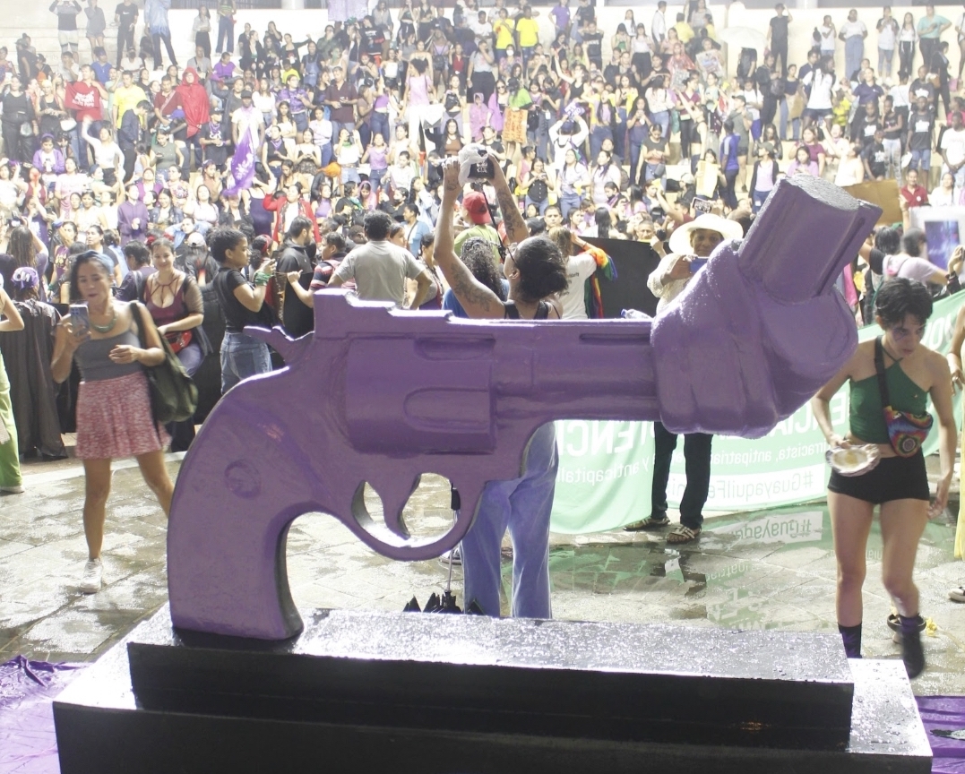 The Knotted Gun in purple with a crowd of people in Ecuador